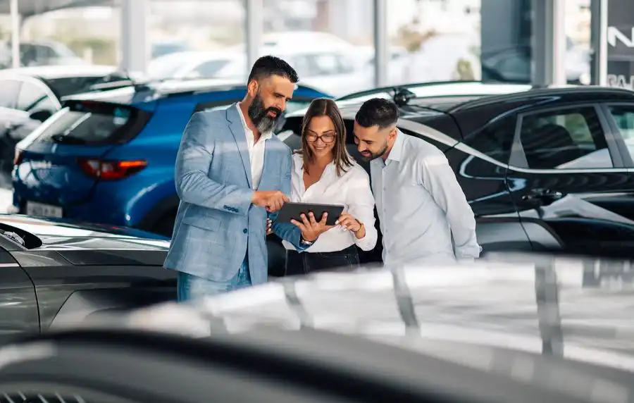 Équipe consultant une tablette dans une concession automobile