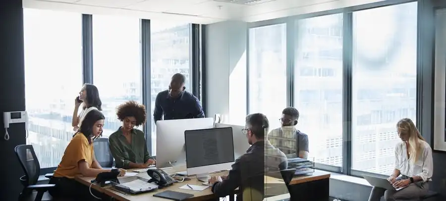 Équipe au travail en open space, postes équipés