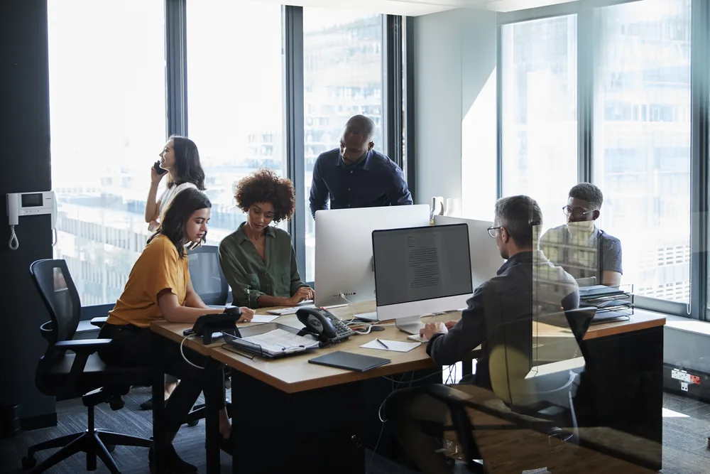 Équipe au travail en open space, postes équipés